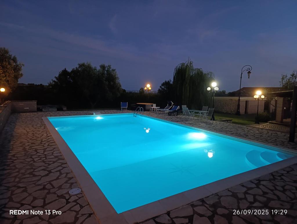 une piscine éclairée la nuit dans l'établissement Villa Anna, à Genzano di Roma