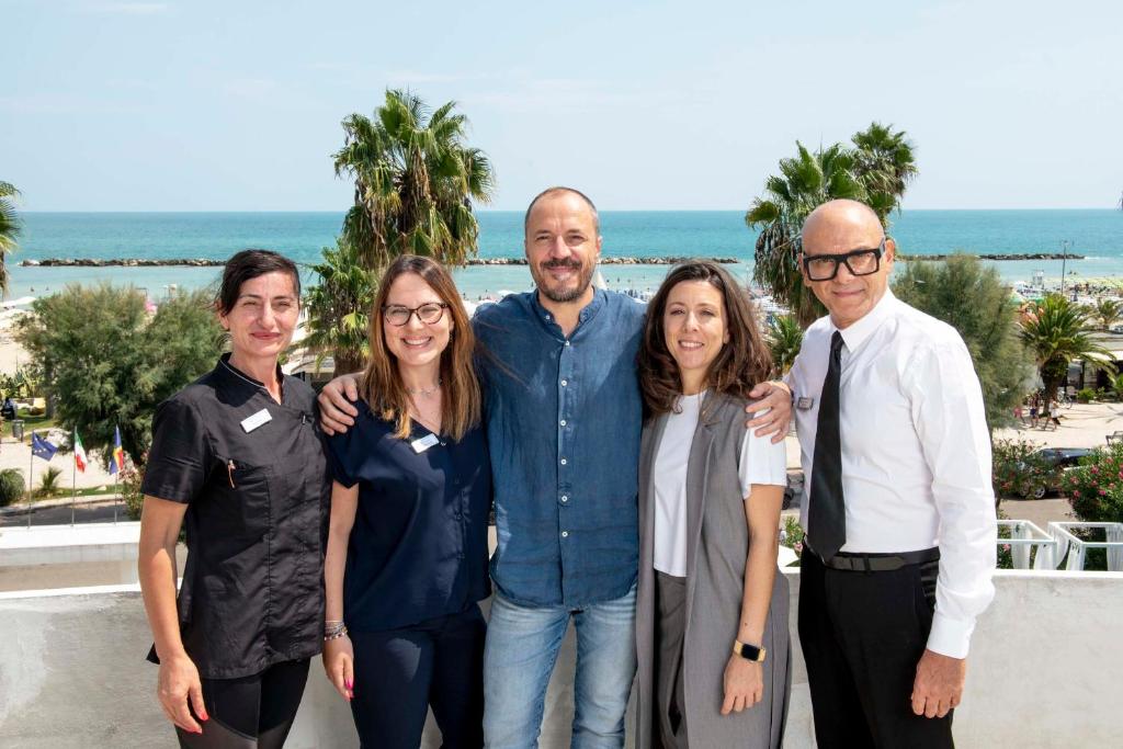 un groupe de personnes posant pour une photo à la plage dans l'établissement International Hotel & Suite - In prima fila sul lungomare, à San Benedetto del Tronto