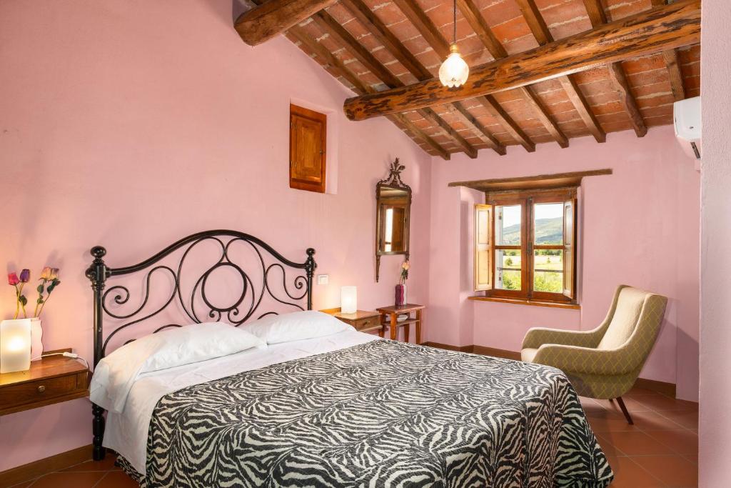 une chambre avec un lit et deux chaises dans l'établissement Villa Cangeli by PosarelliVillas, à Arezzo