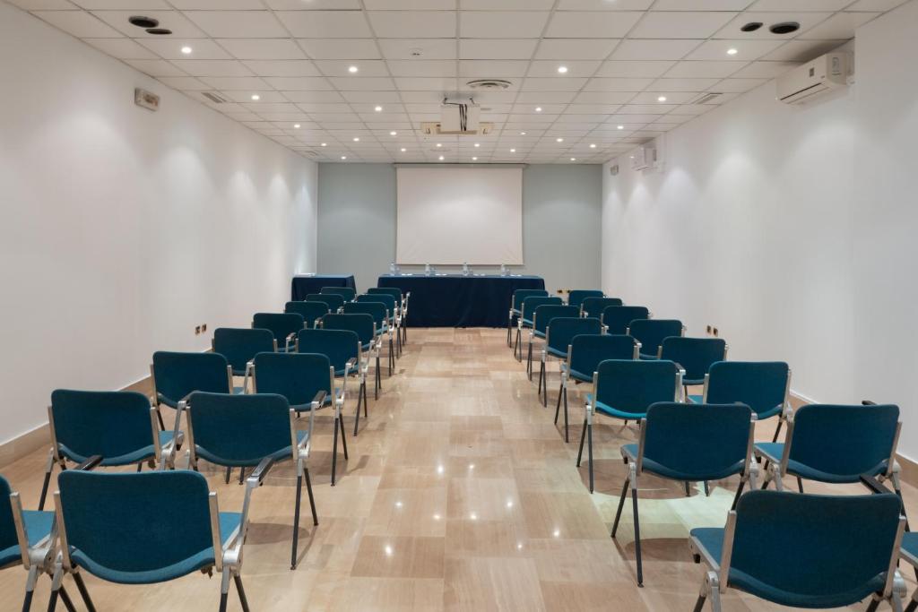 Cette chambre comprend des chaises et un écran blanc. dans l'établissement Hotel Riva Del Sole, à Giovinazzo 97 autres photos