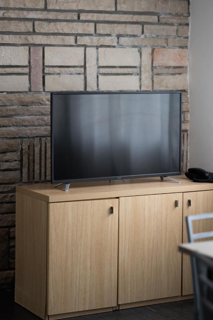 un téléviseur à écran plat posé sur un meuble en bois dans l'établissement Hotel Riva Del Sole, à Giovinazzo