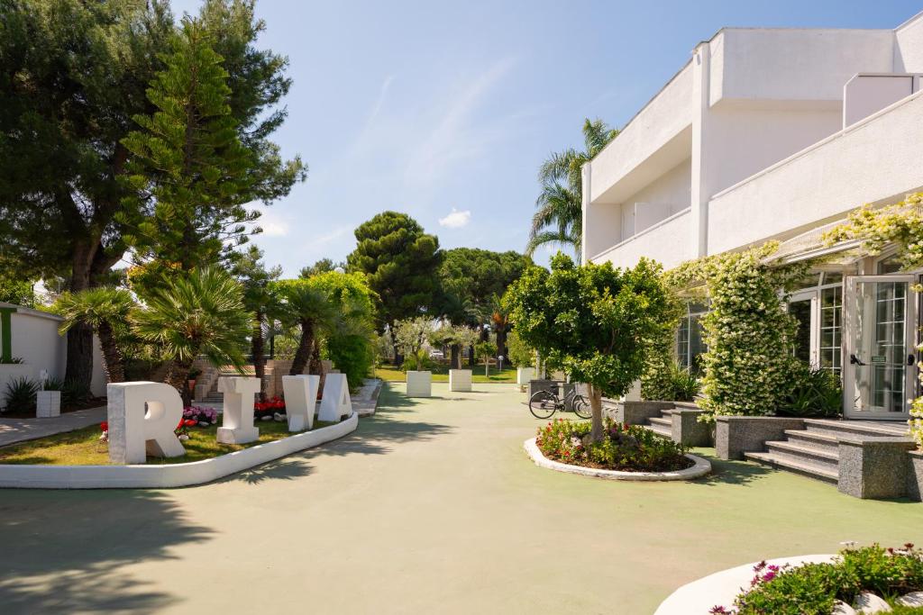 un bâtiment avec une enseigne devant lui dans l'établissement Hotel Riva Del Sole, à Giovinazzo
