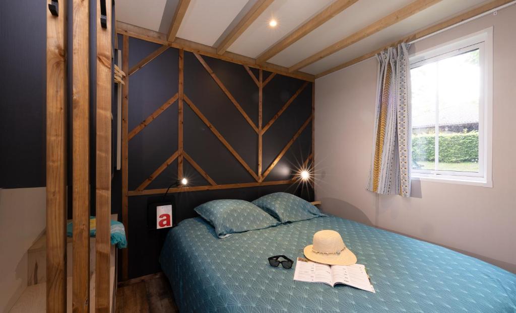 une chambre avec un lit bleu avec un chapeau dessus dans l'établissement Camping La Grappe Fleurie, à Fleurie 89 autres photos