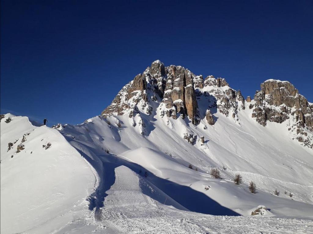 Une montagne enneigée avec un ciel bleu dans l'établissement Duplex dans chalet au coeur de la station, à Réallon