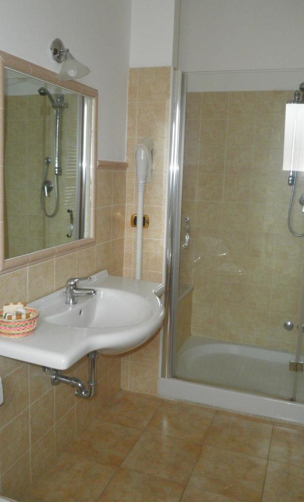 une salle de bain avec un lavabo et une douche dans l'établissement Hotel Il Corsaro, à Le Castella