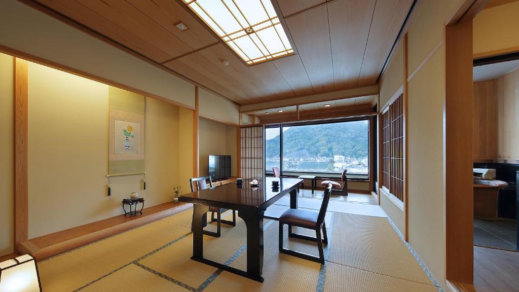 une salle à manger avec une table et des chaises et une fenêtre dans l'établissement Izu Mitohama Shotokan, à Numazu