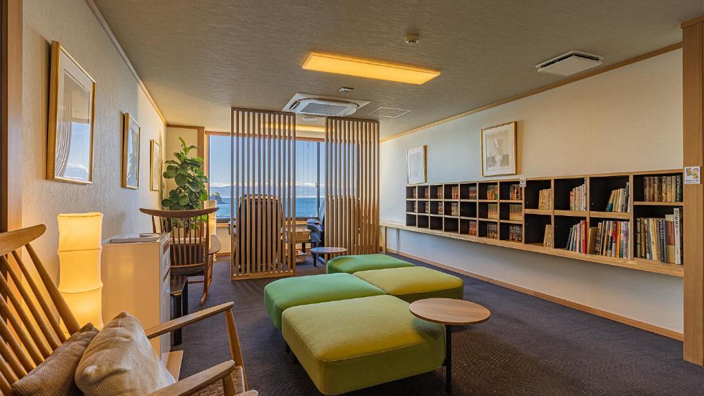 un salon avec un canapé et une étagère dans l'établissement Izu Mitohama Shotokan, à Numazu