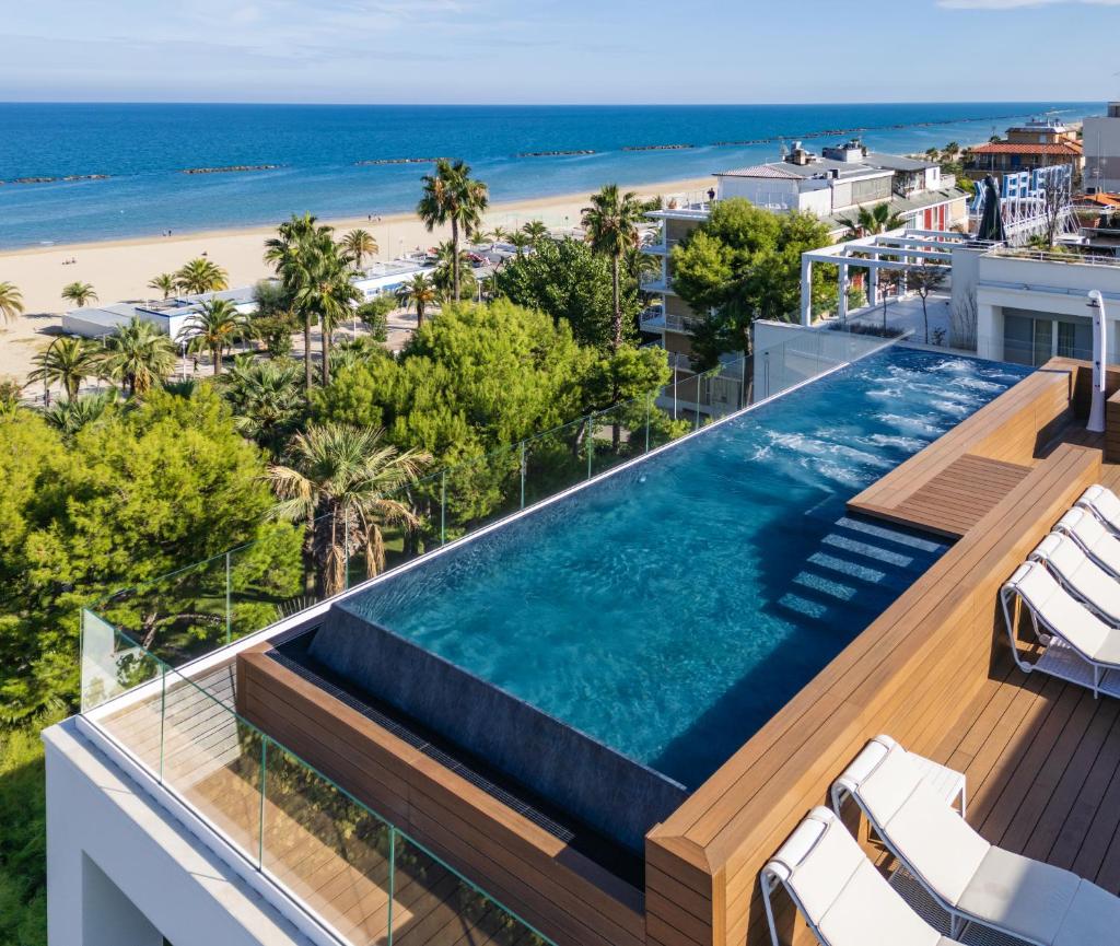 une piscine à débordement au sommet d'un immeuble avec la plage dans l'établissement Hotel Relax Family & Spa, à San Benedetto del Tronto
