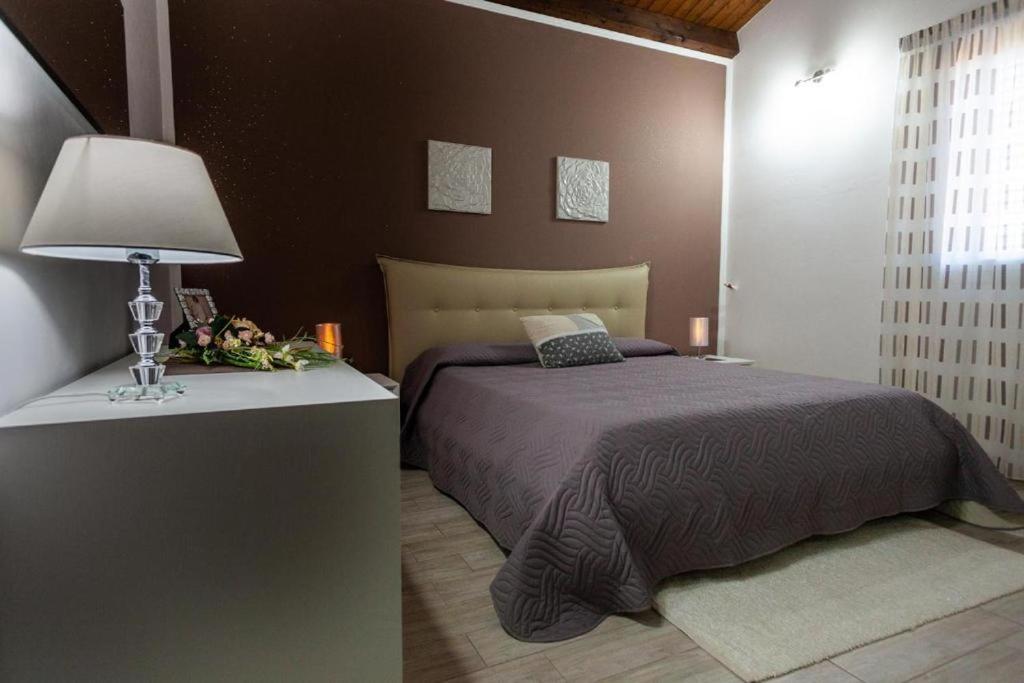 une chambre avec un lit et une table avec une lampe dans l'établissement Villa Concita, à Noto