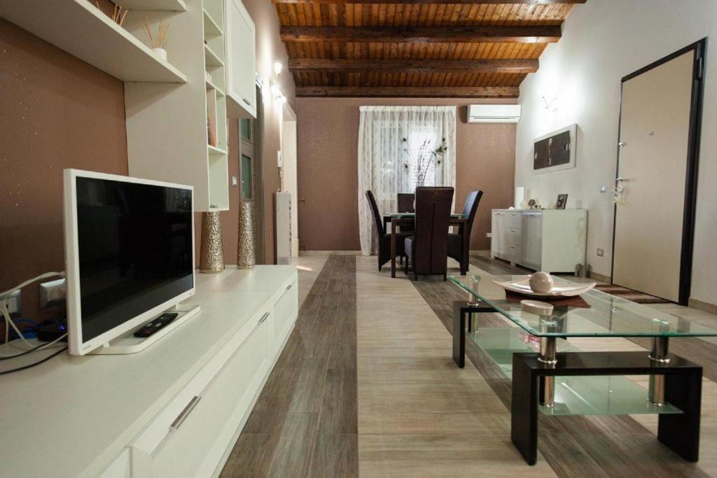 un salon avec une télévision et une table en verre dans l'établissement Villa Concita, à Noto