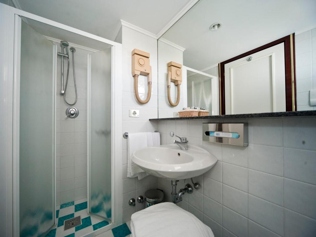 une salle de bain avec un lavabo, une douche et des toilettes dans l'établissement Hotel Beny, à Lido di Jesolo