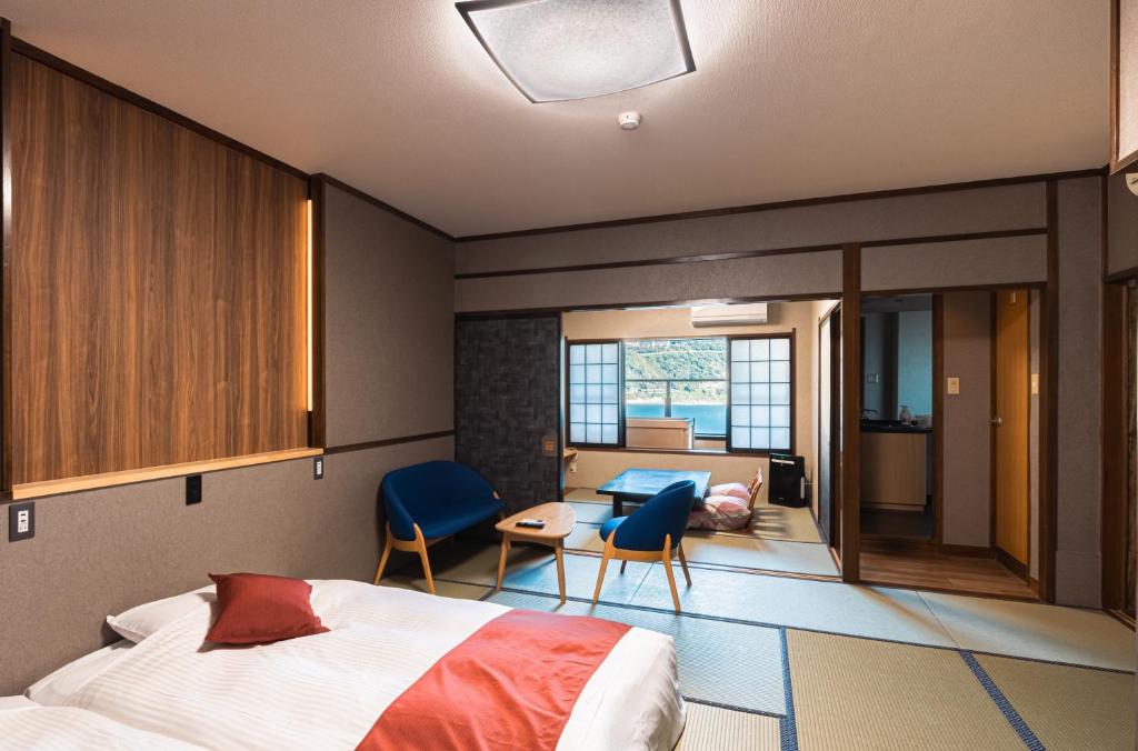 une chambre avec un lit et un salon dans l'établissement Inatori Akao Hotel, à Higashiizu