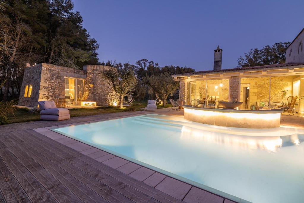 une piscine devant une maison dans l'établissement Tenuta Arcàdia, à Cursi