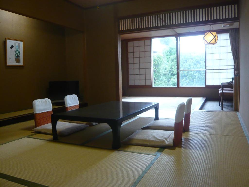 un salon avec une table et des chaises et une fenêtre dans l'établissement Konya, à Matsue 38 autres photos