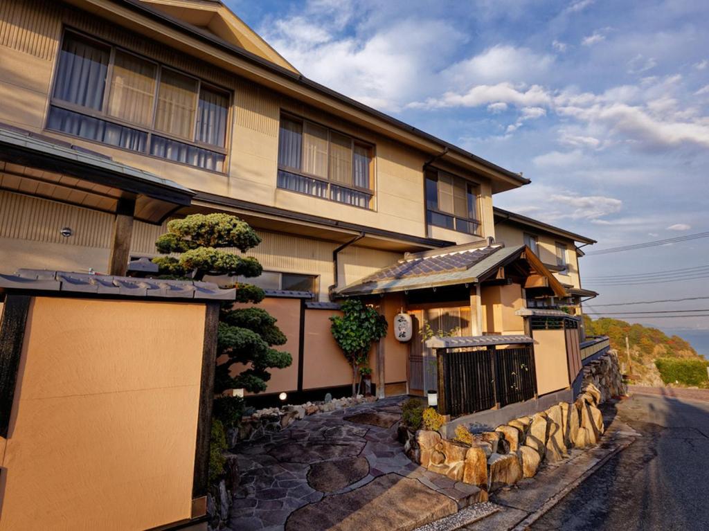 une grande maison avec un portail et une allée en pierre dans l'établissement Donkairo, à Ako