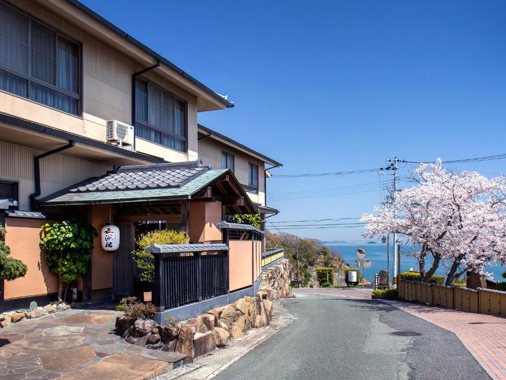 une rue devant un immeuble avec des arbres en fleurs dans l'établissement Donkairo, à Ako