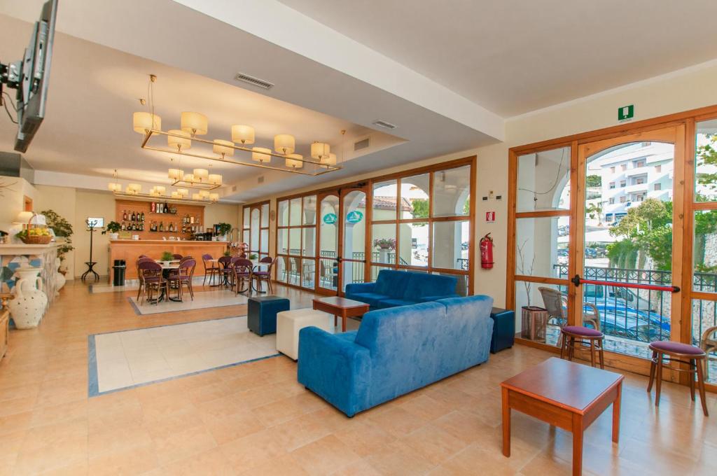 un salon avec un canapé bleu et une table dans l'établissement Park Hotel Villa Americana, à Rodi Garganico