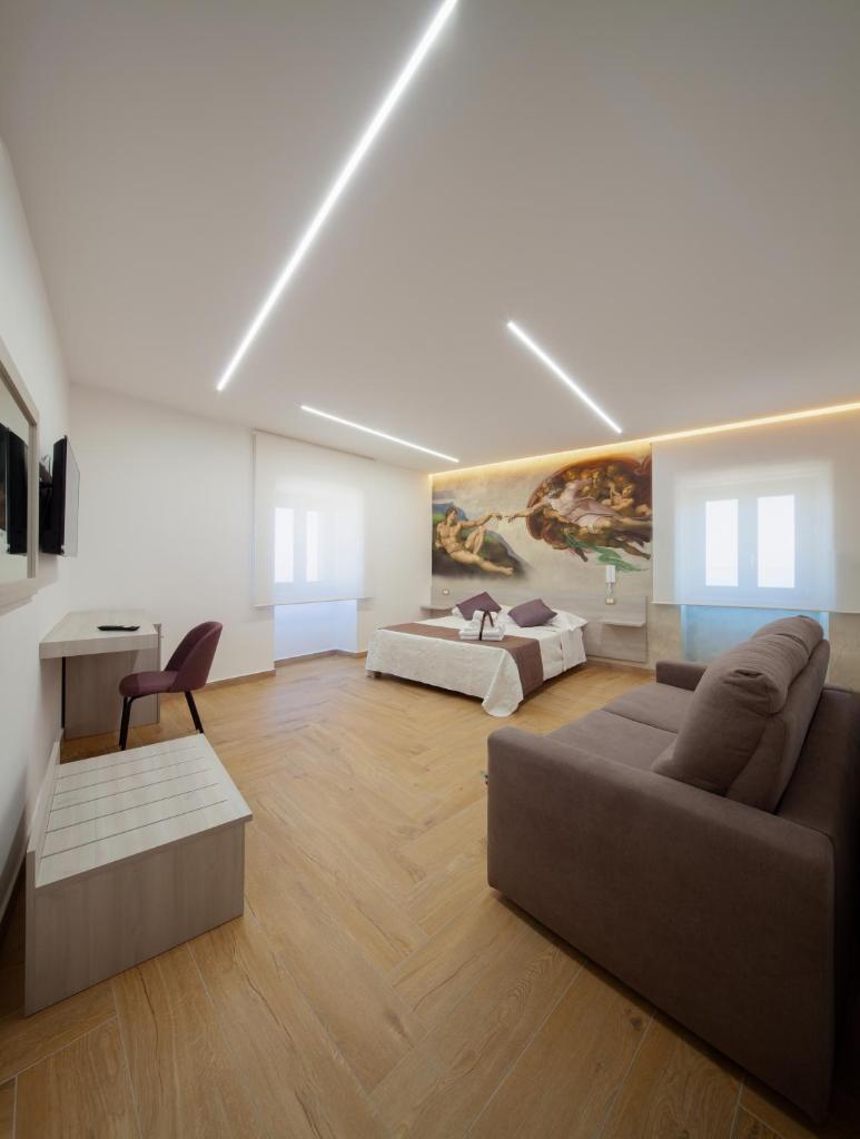 un grand salon avec un canapé et un lit dans l'établissement Palazzo Fiorentini Charme Hotel, à Cariati