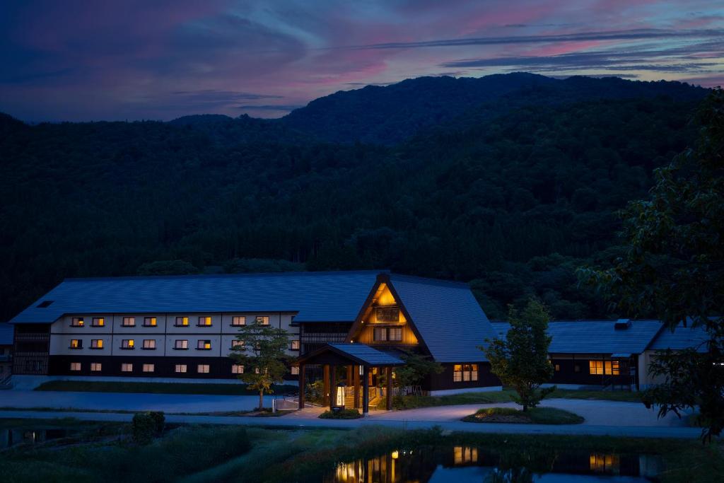 une grange la nuit avec les montagnes en arrière-plan dans l'établissement Onyado Yuinosho, Shirakawago, à Shirakawa-gō