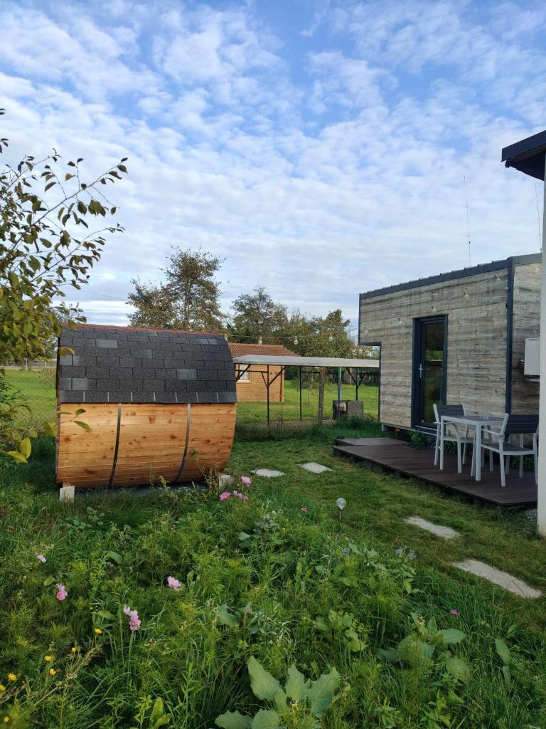 un tonneau en bois posé dans une cour à côté d'un bâtiment dans l'établissement Maisonnette des trois frontières, à Richwiller