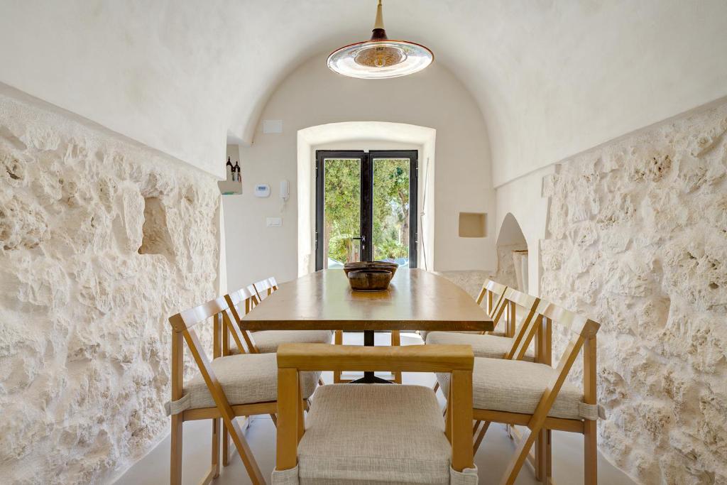 une salle à manger avec une table et des chaises en bois dans l'établissement LaCasa Puglia, à Ceglie Messapica