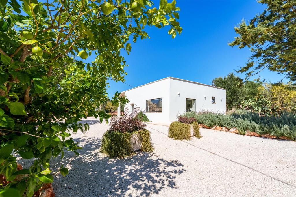 un bâtiment blanc avec des plantes devant lui dans l'établissement LaCasa Puglia, à Ceglie Messapica