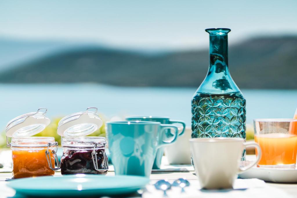 - une table avec une bouteille, des tasses et des boissons dans l'établissement Le Ville Le Saline, à Palau