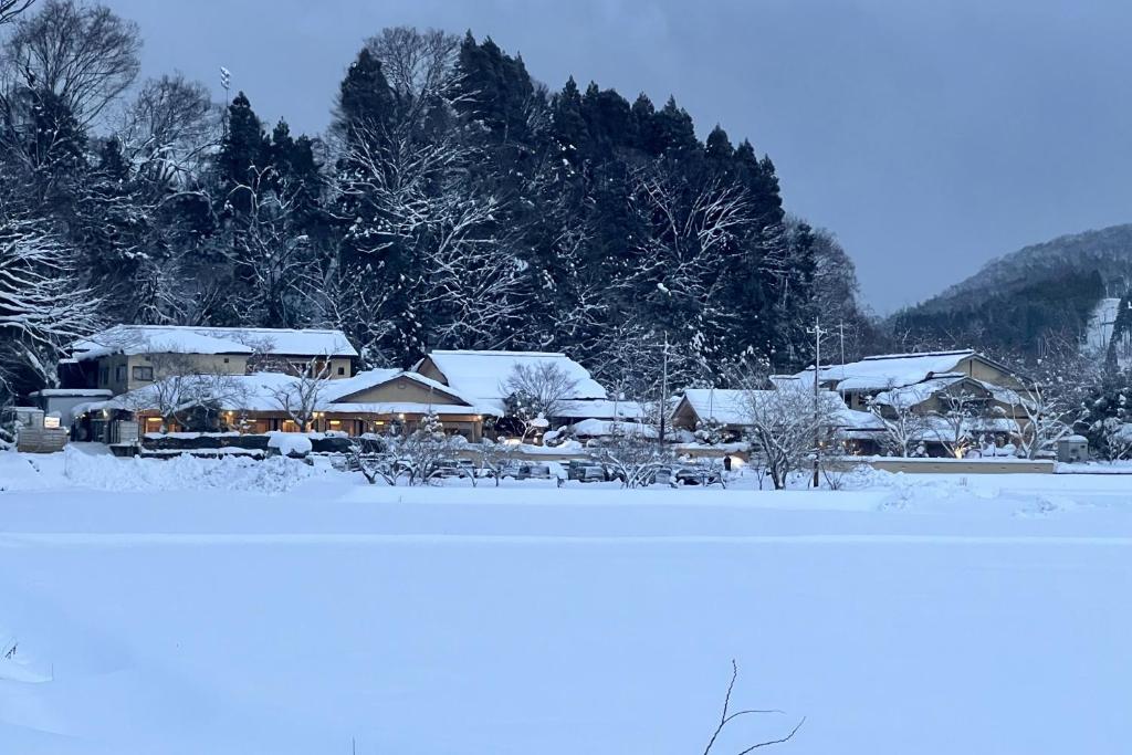 un groupe de maisons couvertes de neige dans l'établissement TAKITEI Riverside Onsen ーA Hidden Ryokan in Kanazawaー, à Kanazawa