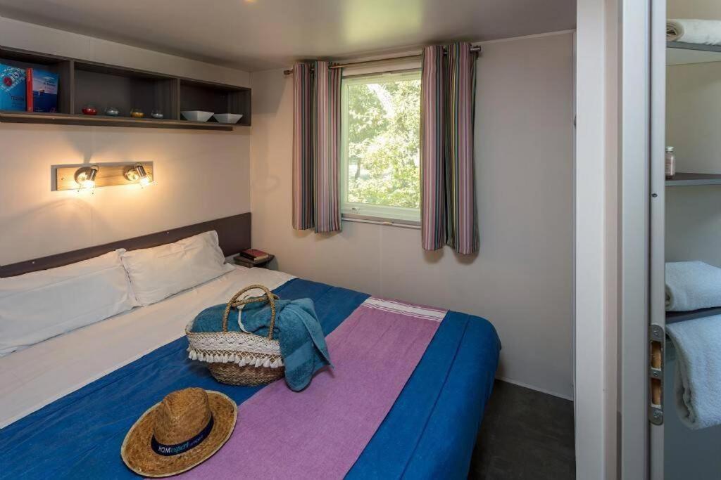 une chambre avec un lit avec un chapeau dessus dans l'établissement Camping Le Chêne Gris, à Pommeuse