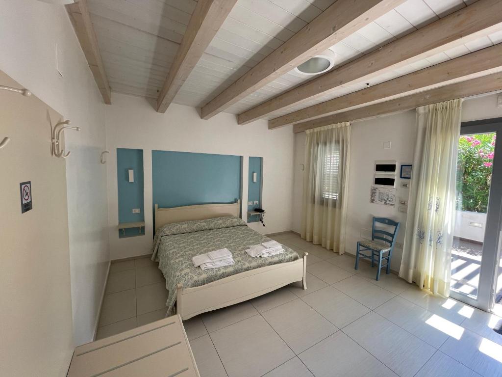 une chambre avec un lit et une chaise dedans dans l'établissement Baia Sangiorgio Hotel & Beach Club, à Bari 40 autres photos