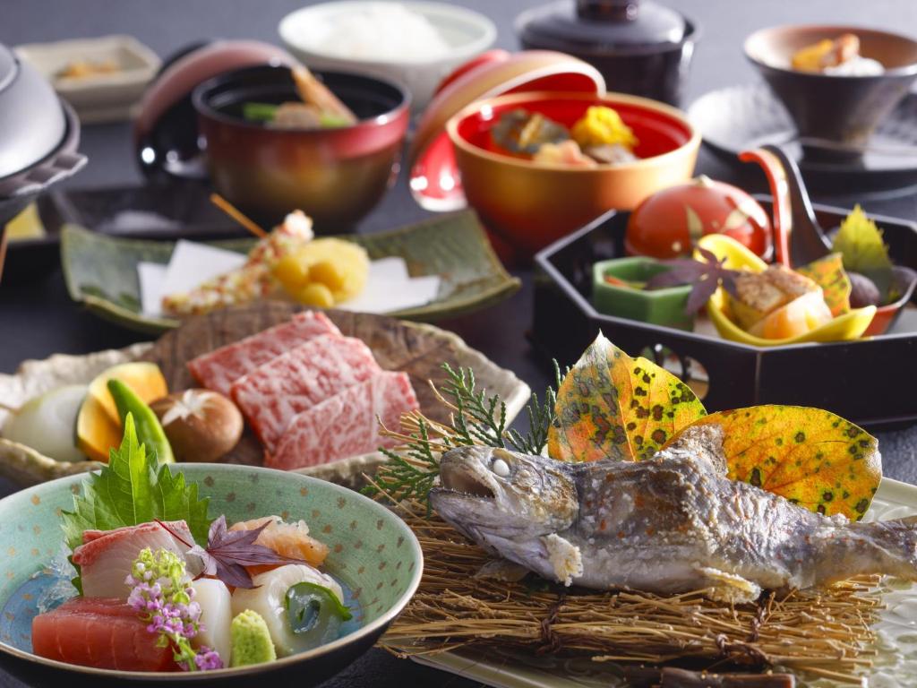 une table sur laquelle sont posées des assiettes de nourriture avec un poisson dans l'établissement Matsusaka Doggie Paradise Hotel Smeall, à Matsuzaka