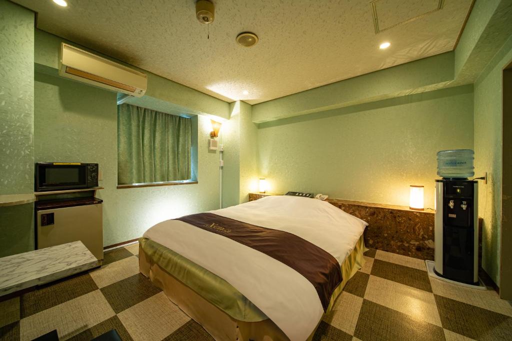 une chambre avec un grand lit dans une pièce dans l'établissement Hotel Xenia Mikumo (Adult Only), à Konan