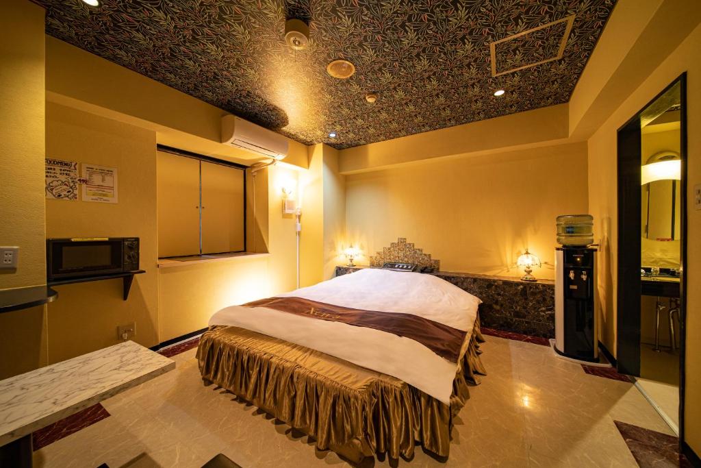 une chambre avec un grand lit dans une pièce dans l'établissement Hotel Xenia Mikumo (Adult Only), à Konan