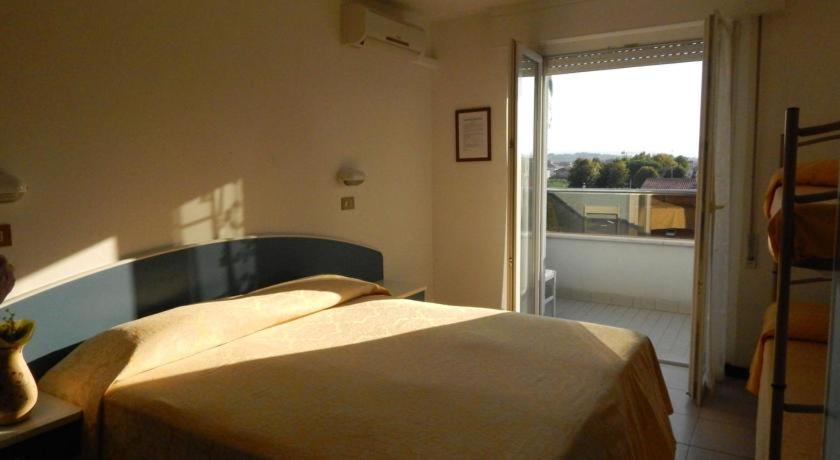 une chambre avec un lit et une grande fenêtre dans l'établissement Hotel Wilma, à Rimini