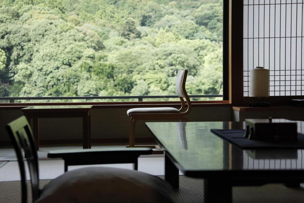 une pièce avec une table et des chaises et une grande fenêtre dans l'établissement Kotohira Onsen Kotosankaku, à Kotohira