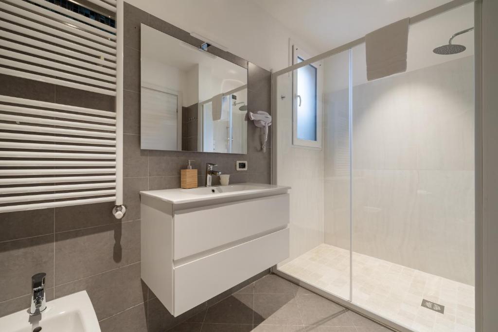 une salle de bain avec un lavabo blanc et une douche dans l'établissement Hotel La Pergola di Venezia, sur le Lido de Venise