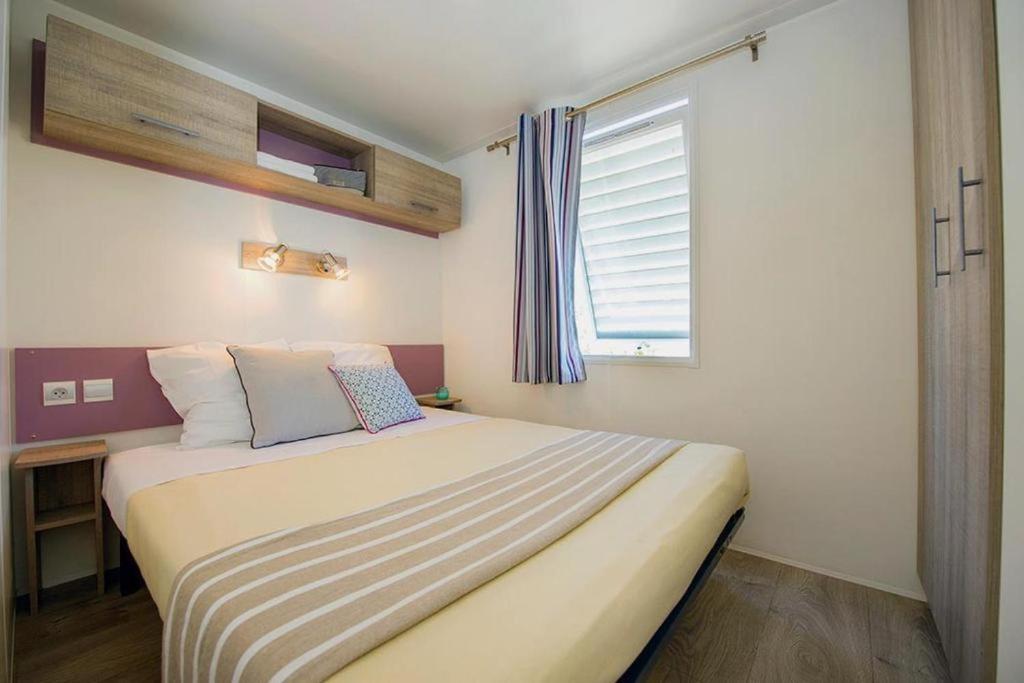 une chambre avec un grand lit avec une fenêtre dans l'établissement Camping Le Chêne Gris, à Pommeuse 40 autres photos