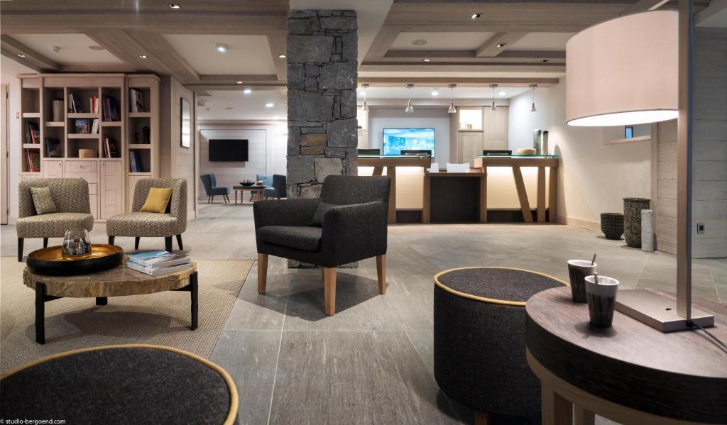 un hall d'entrée avec des chaises et des tables dans une pièce dans l'établissement MGM Hôtels & Résidences - Résidence Le Roc Des Tours, au Grand-Bornand