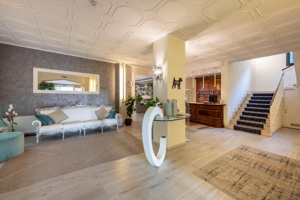 un salon avec un canapé et un escalier dans l'établissement Olimpia Hotel & Aparthotel, à Bibione