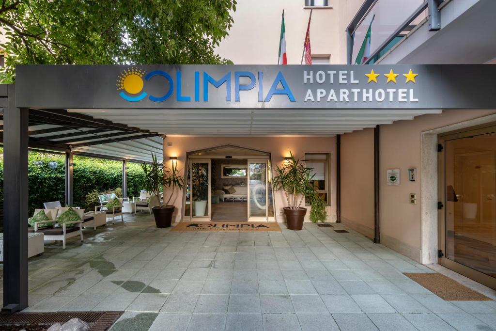 une entrée d'hôtel avec un panneau indiquant Olympia Hotel Apartment dans l'établissement Olimpia Hotel & Aparthotel, à Bibione 86 autres photos