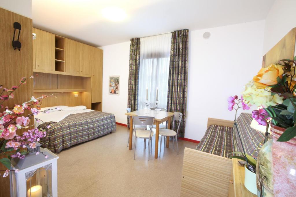 une chambre d'hôtel avec un lit, une table et des chaises dans l'établissement Daina Residence, à Lido di Jesolo