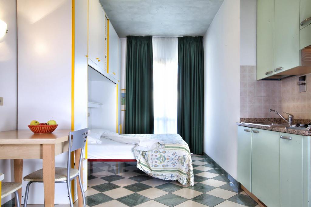 une petite pièce avec un lit et une table dans l'établissement Daina Residence, à Lido di Jesolo 13 autres photos