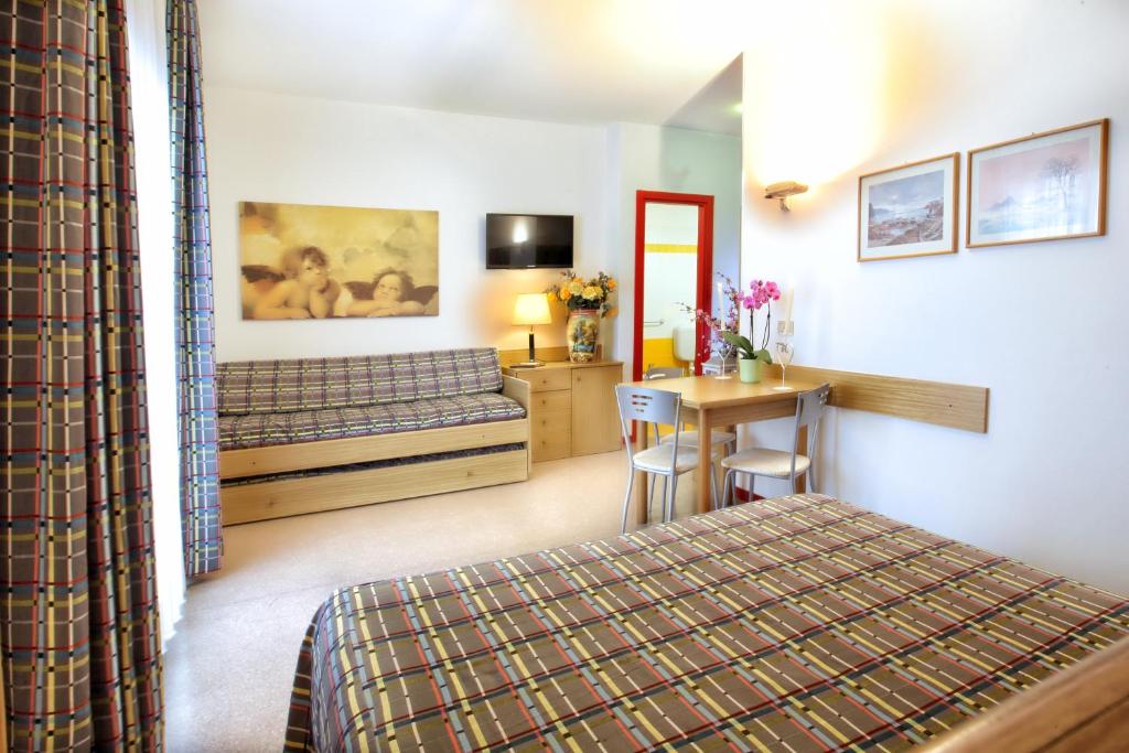 une chambre avec un lit, un bureau et une table dans l'établissement Daina Residence, à Lido di Jesolo