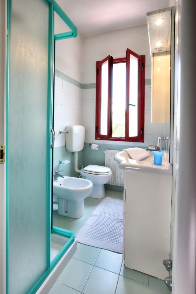 une salle de bain avec toilettes, lavabo et douche dans l'établissement Daina Residence, à Lido di Jesolo
