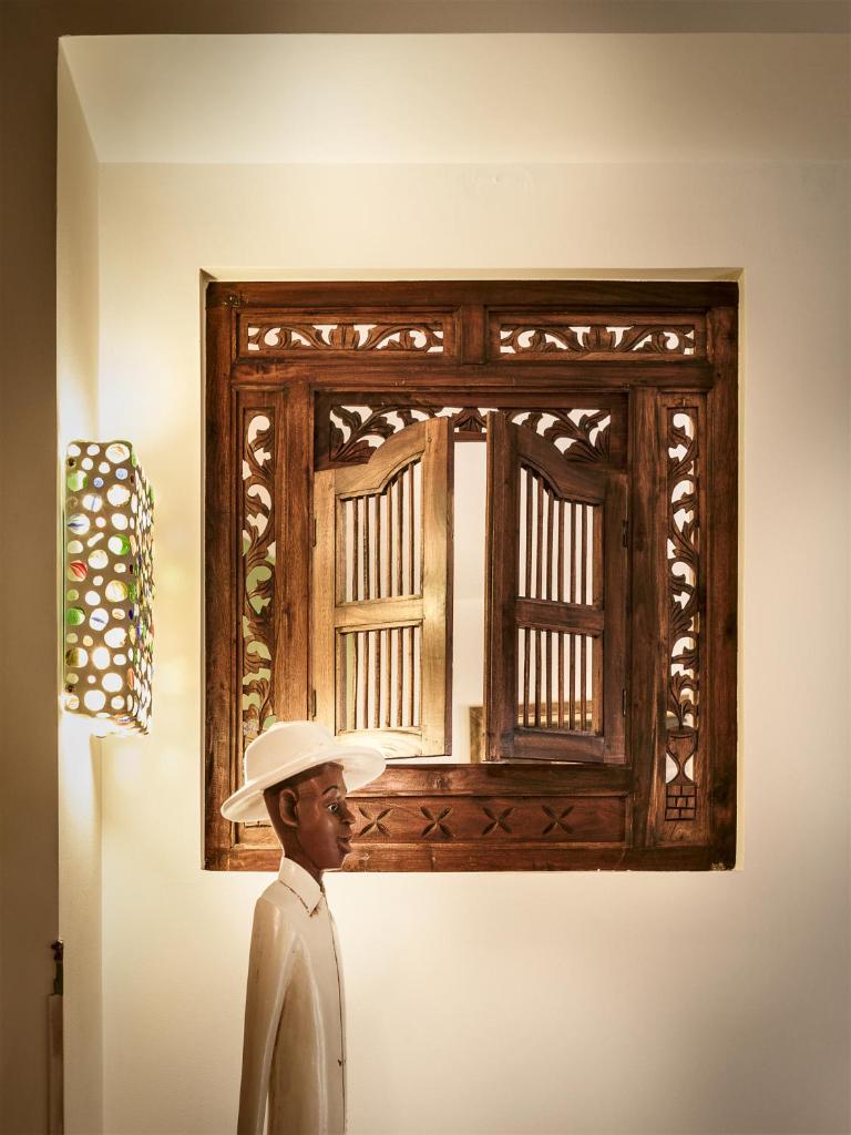 Un homme dans un chapeau debout devant une photo sur un mur dans l'établissement Hotel Stella Maris, à Villasimius 158 autres photos