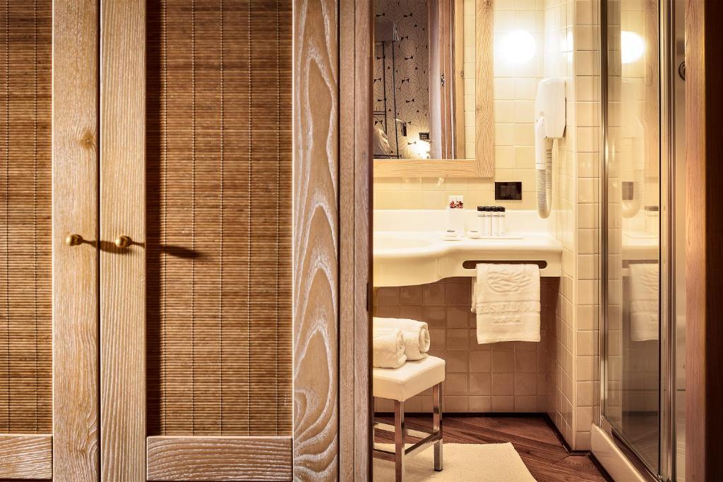 une salle de bain avec un lavabo, des toilettes et un miroir dans l'établissement Hotel Stella Maris, à Villasimius