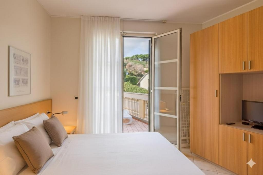 - une chambre avec un lit blanc et une porte coulissante en verre dans l'établissement Residenza al Porto, à Spotorno 126 autres photos