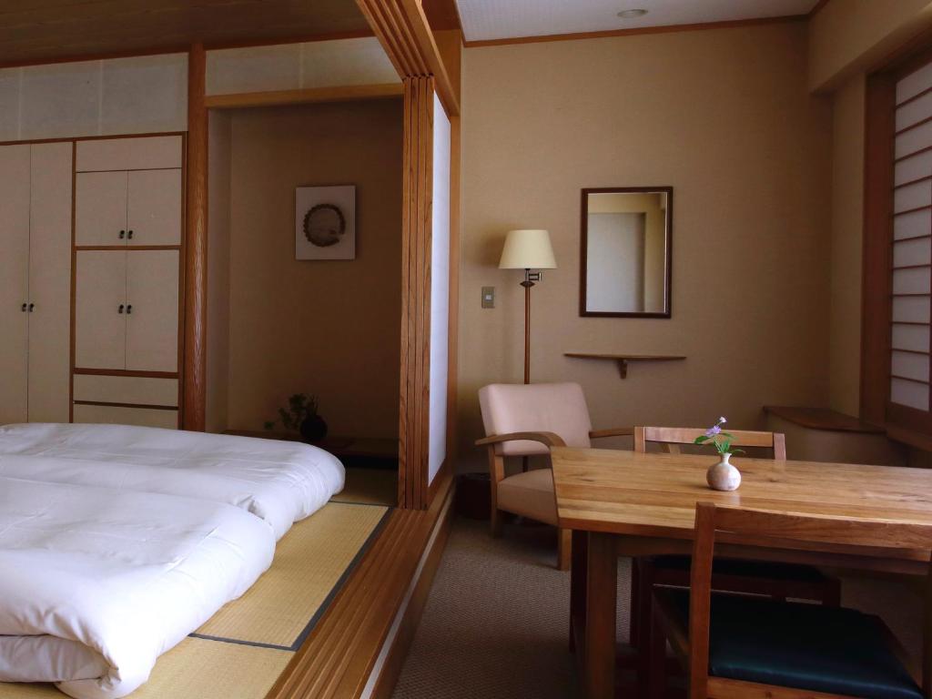 une chambre avec un lit et une table et une salle à manger dans l'établissement Itamuro Onsen Daikokuya, à Nasushiobara