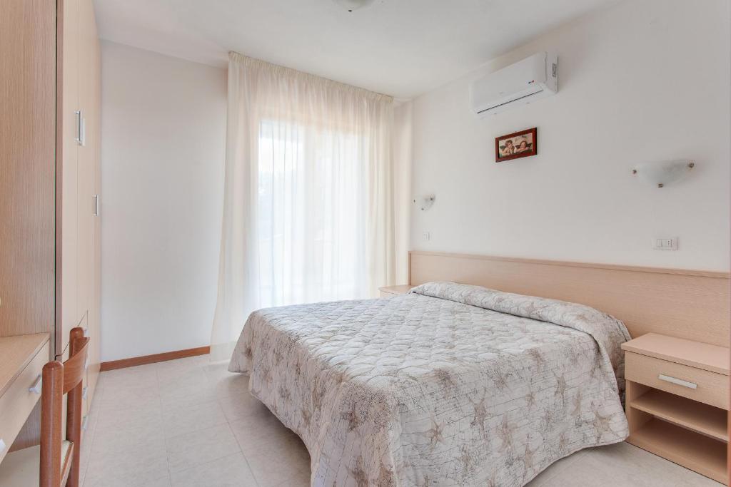 une chambre avec un lit et une fenêtre dans l'établissement Aparthotel Costa Paradiso, à Lido Adriano