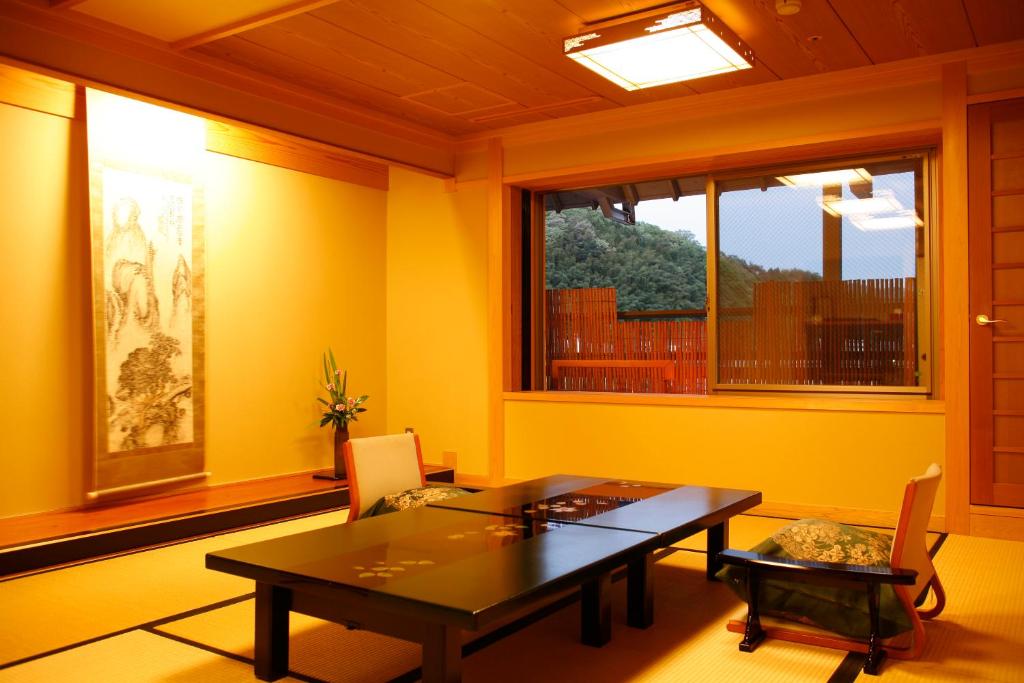 une salle à manger avec une table et une fenêtre dans l'établissement Asanoya, à Yumura